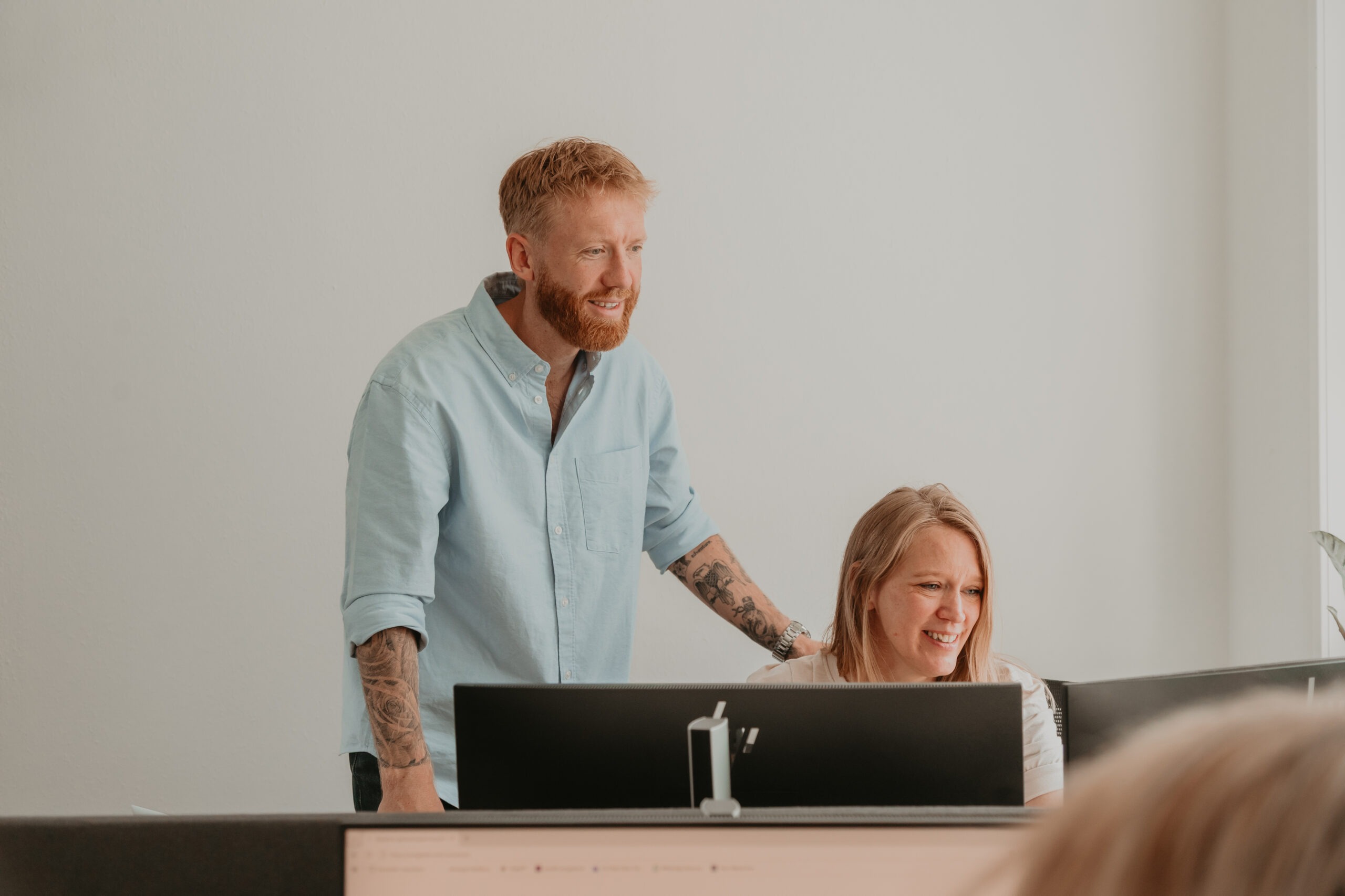 Twee collega’s van ZorgSterk bekijken samen een computerscherm op kantoor