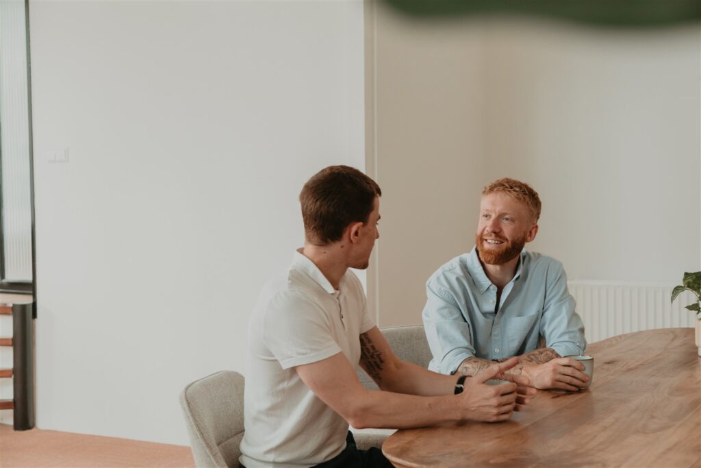 Twee collega’s van ZorgSterk voeren een gesprek aan tafel op kantoor